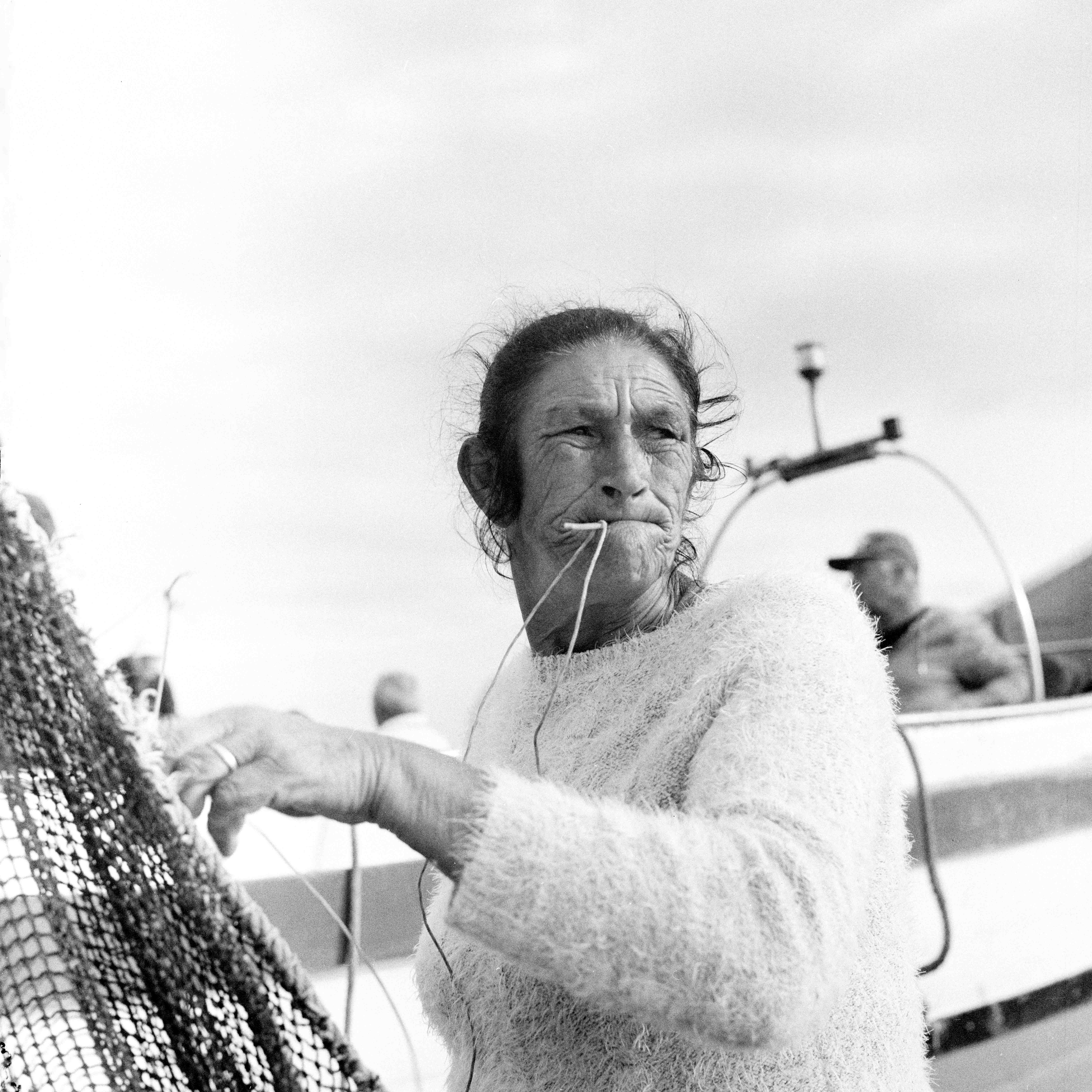 Portrait of a Woman called Guida, she is seen with a utensil in her mouth used to tie the nets used by the fishermen.