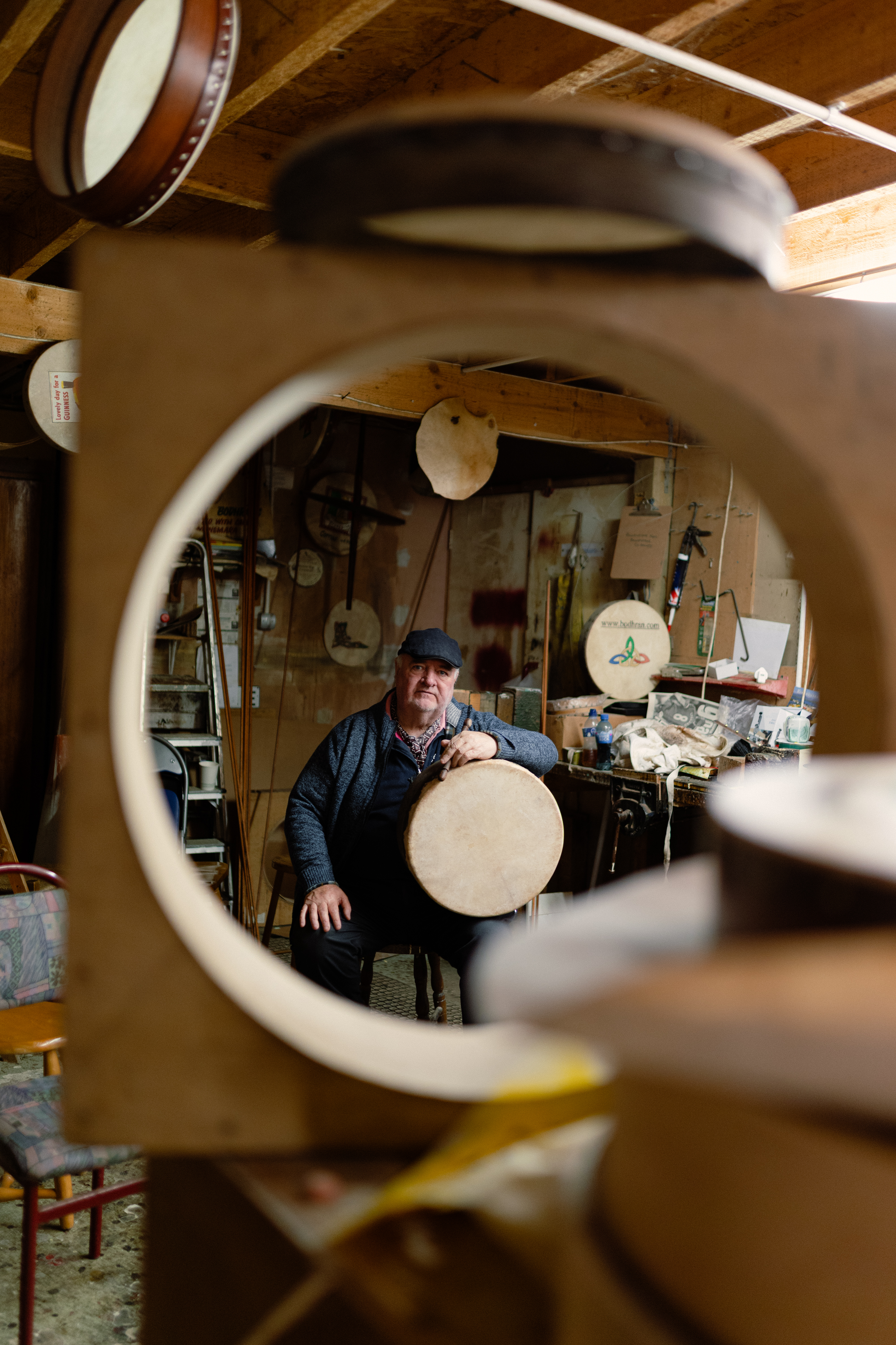 A man sitting in his Bodrán Workshop, amongst his work.