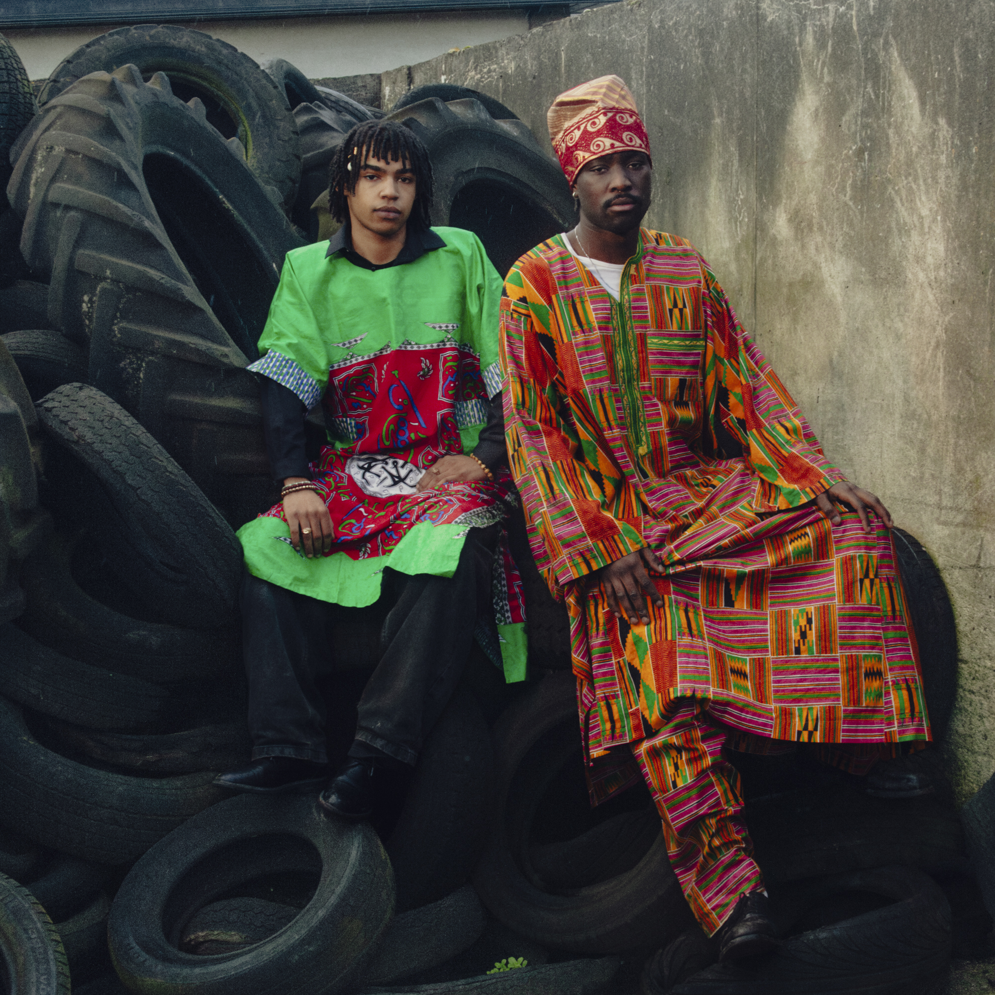 two men sitting on tyres