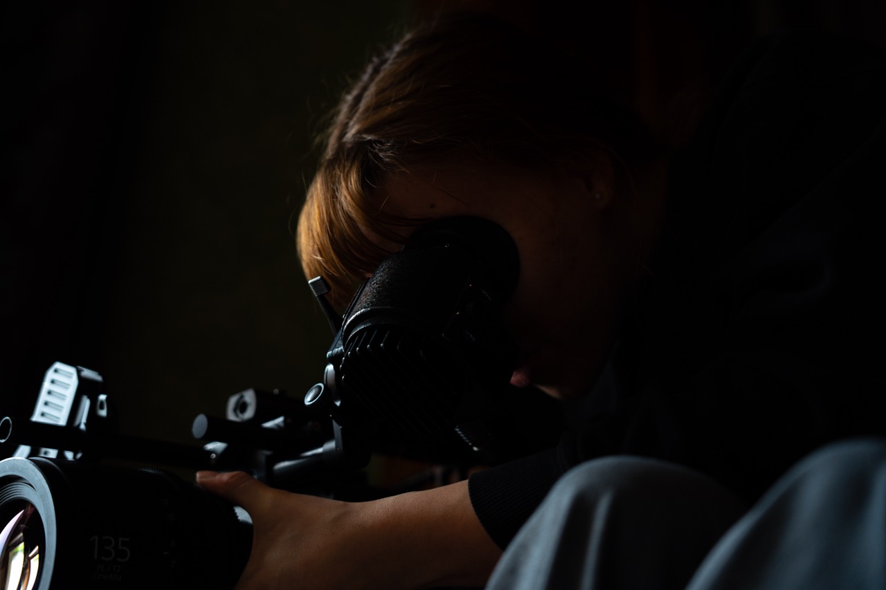 maria looking through the camera viewfinder