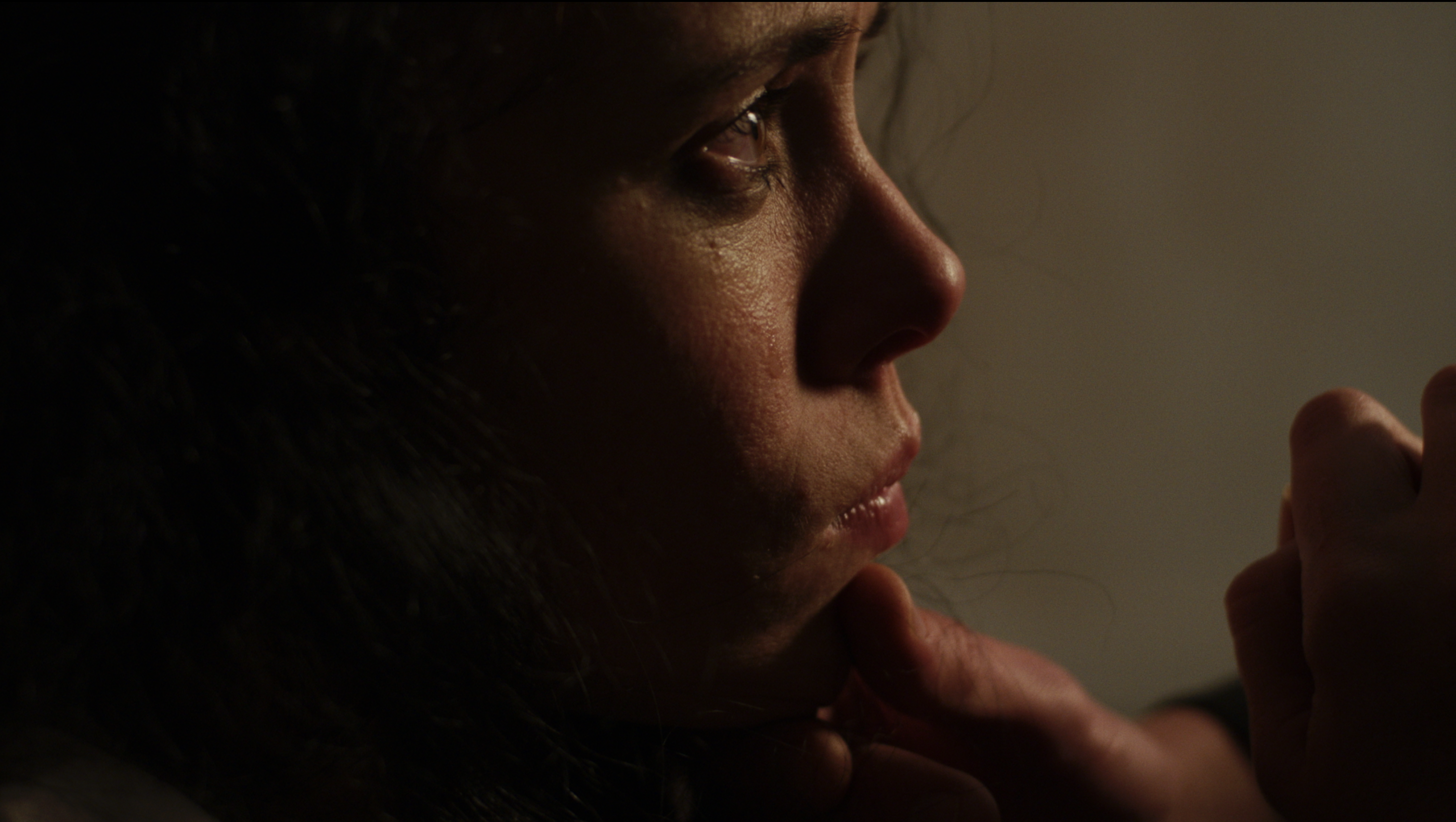 Elena (Kate Finnegan) looks left as someone grabs her chin