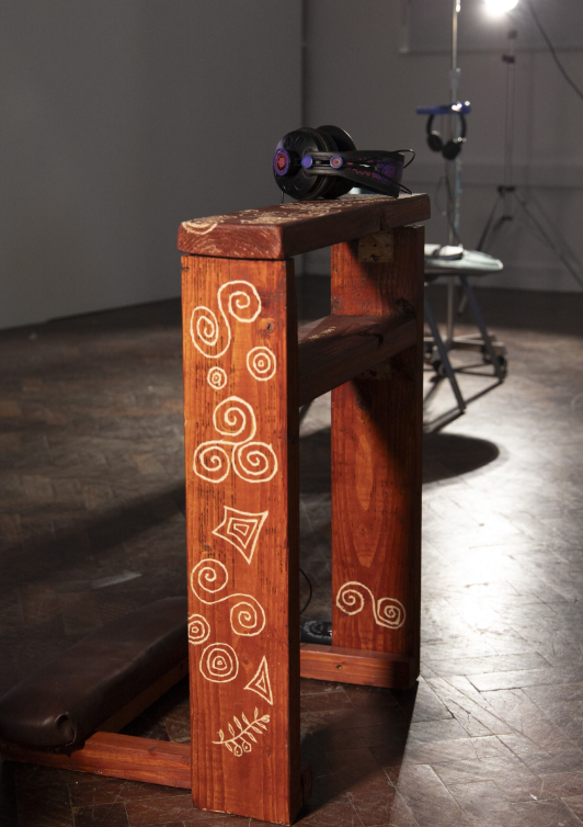 Personal prayer bench with celtic inspired carvings and headphones sitting on top. 