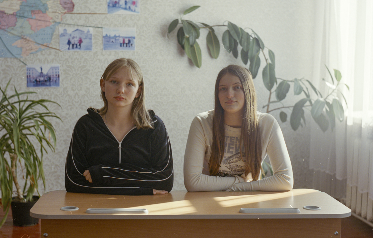 Two girls are sitting at the desk.
