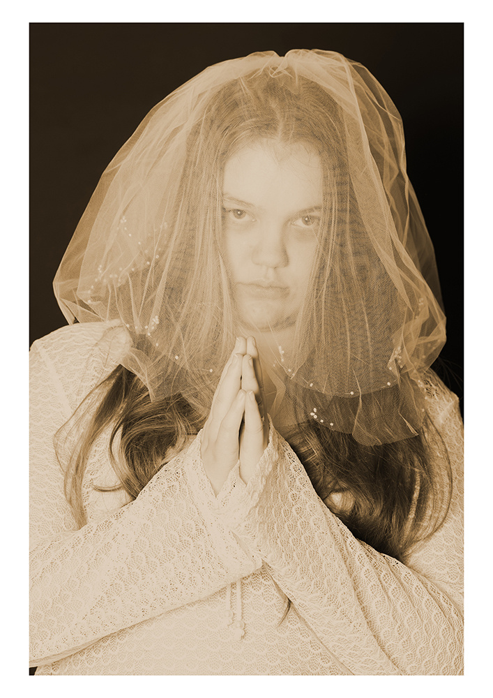 A woman wearing white and a veil over her head
