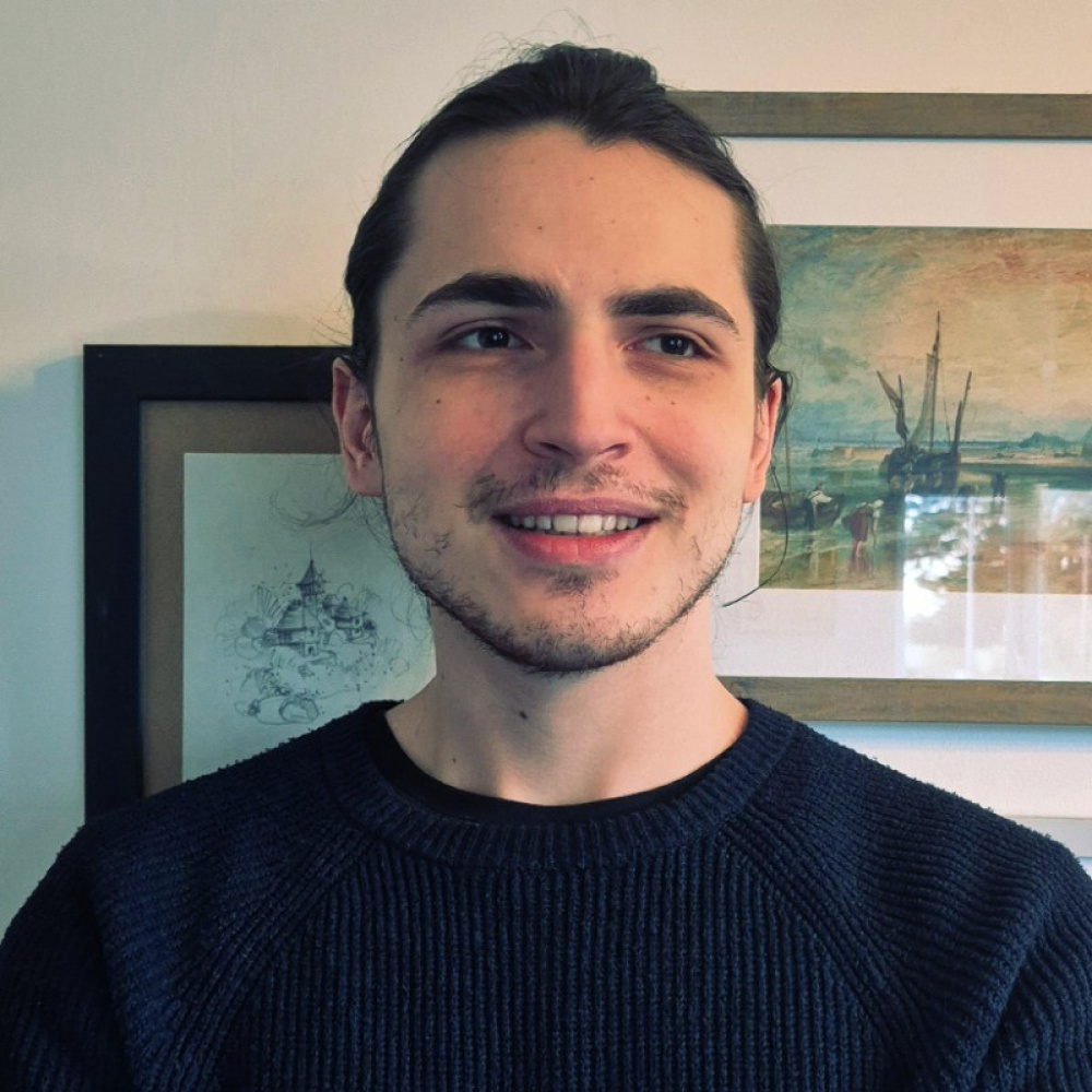 Image of Jan Pantic standing next to two paintings